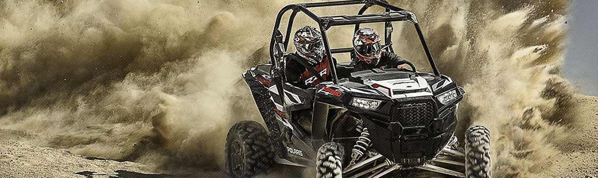 Two UTV riders are speeding through Farmer's Branch, Texas, kicking up a cloud of dust in their fast…